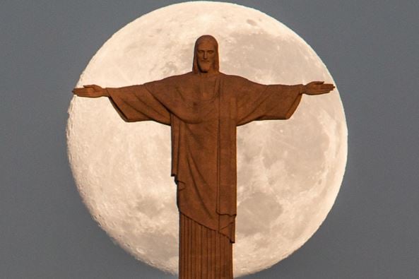 Moon behind statue of Christ in Rio