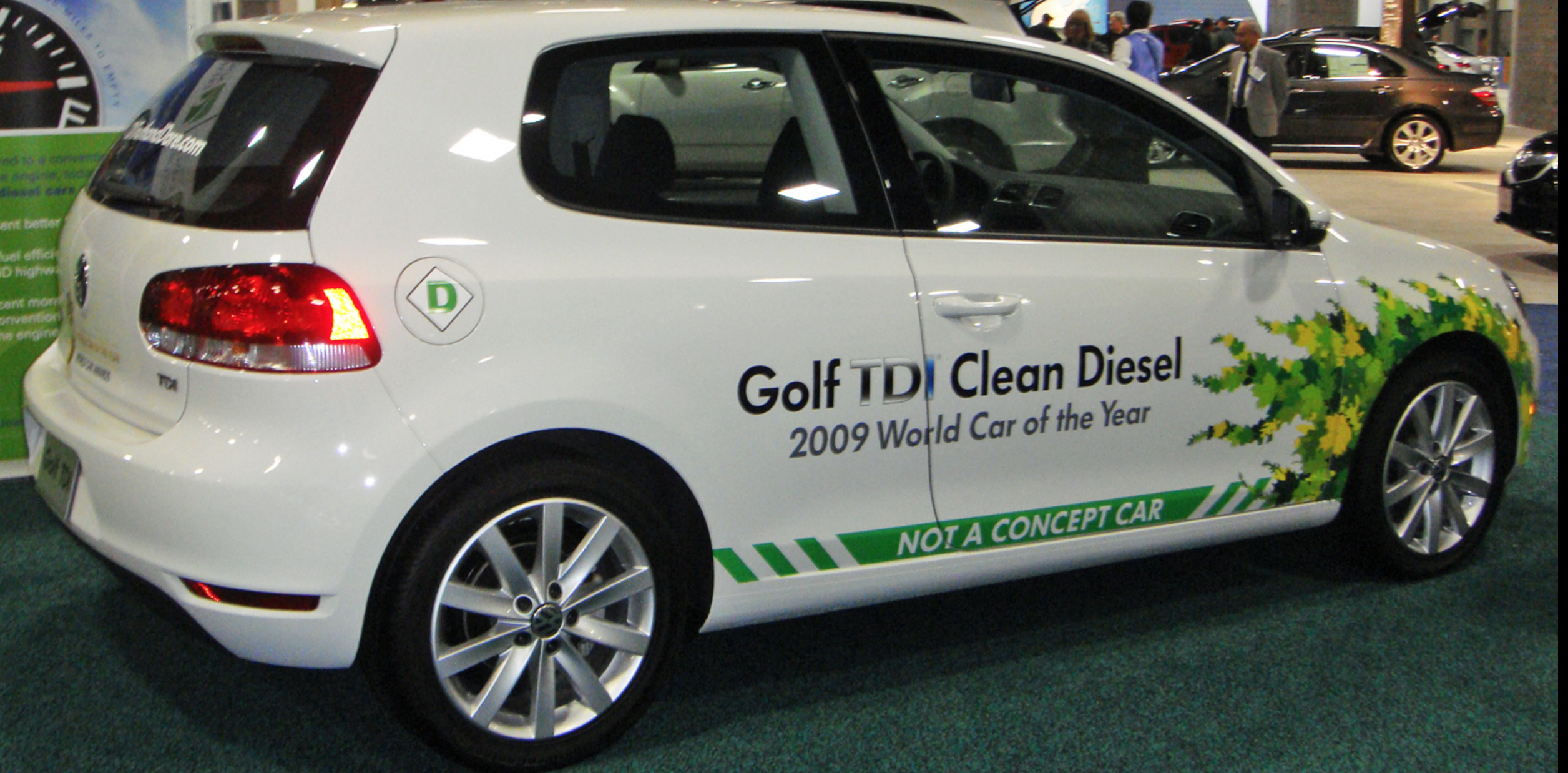 2010 VW Golf TDI with defeat device displaying "Clean Diesel" at a US auto show