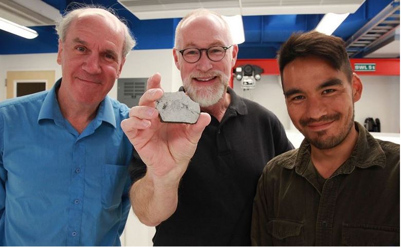 Space scientists holding a sample of Moon rock