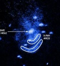 Supermassive black hole that burps and two arcs