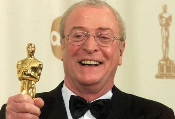 Photo of Michael Caine holding an Oscar statue in his hand.