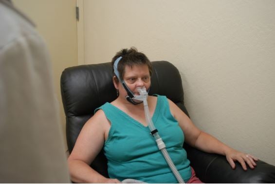 Sleep apnea remedies article - woman using CPAP machine