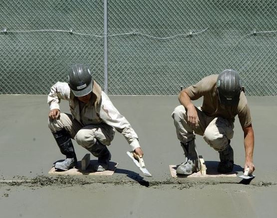 Thumbnail image - Cement and concrete article - thre workers flattening a cement surface