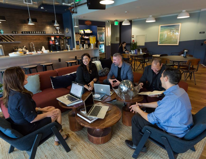 experiential leadership training - group of people with laptops chatting in an informal setting