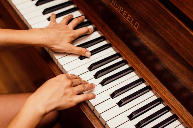 Piano shopping tips for beginners - image person playing piano