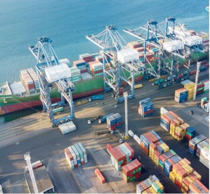 Container ship being unloaded or loaded at port