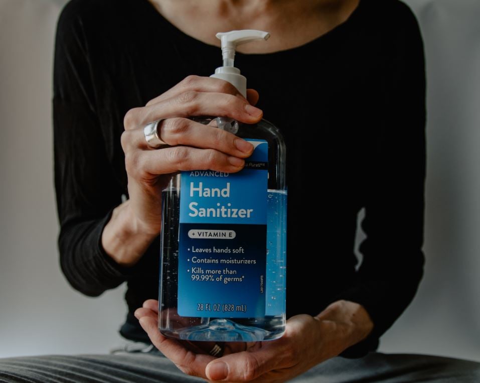 Hand sanitizer image - woman holding container of it
