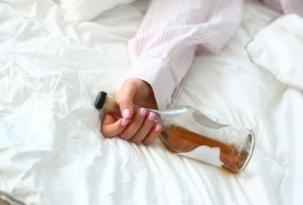 Sleeping holding a bottle of booze