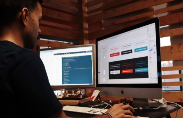 Man working in front of 2 computer monitors