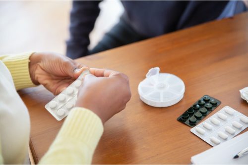 Caregiver getting tablets ready for elderly person