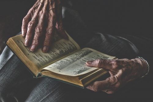Old person holding book open