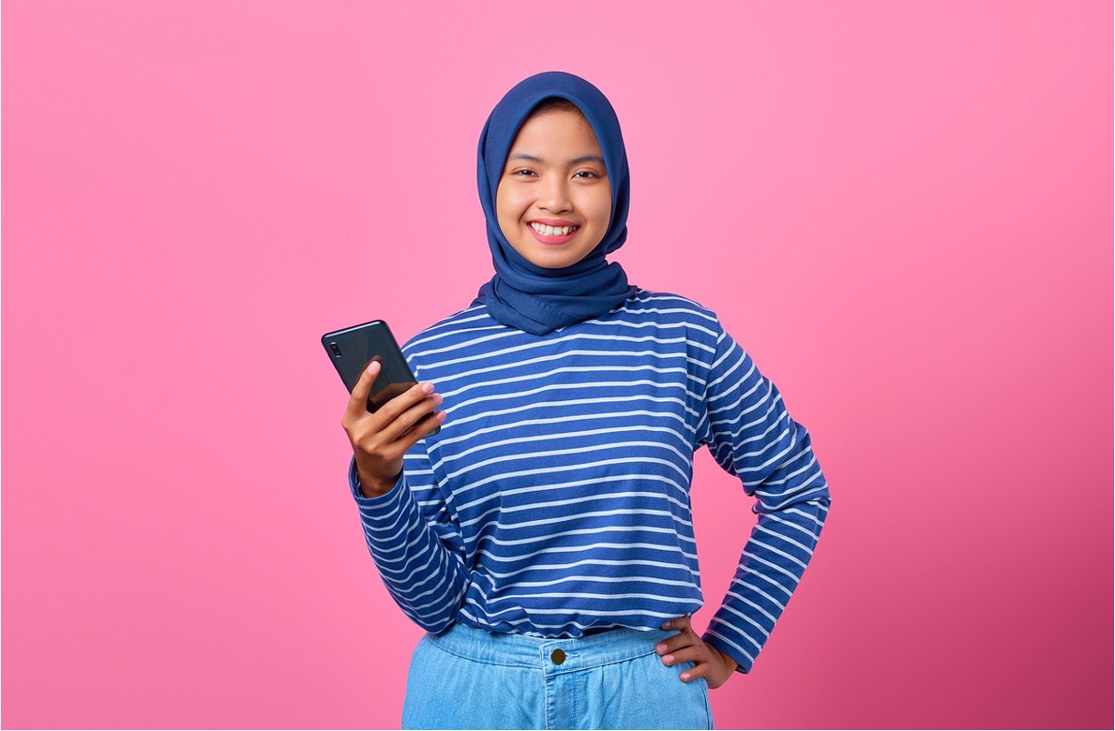 Lady holding mobile - article about Everyday Banking Needs with Islamic Banks