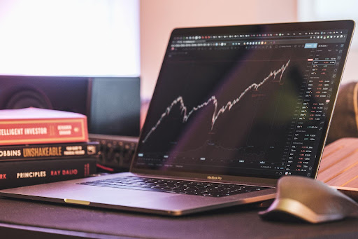 A laptop shows the stock market, representing Ari Stiegler’s financial help