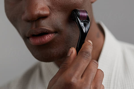 man using a derma roller on his face