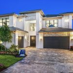 Luxurious modern home design by Misha and Itchko Ezratti's GL Homes at Apex Avenir in Palm Beach Gardens, Florida, showcasing elegant architecture and lush landscaping