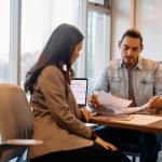 A male entrepreneur reviewing different loans for new businesses.