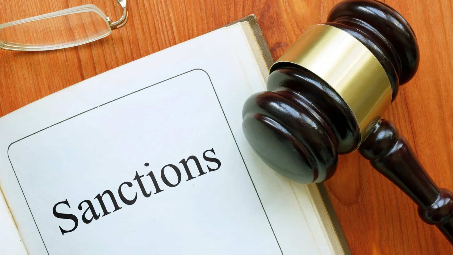 Sanctions text on desk in a book with a gavel next to the word