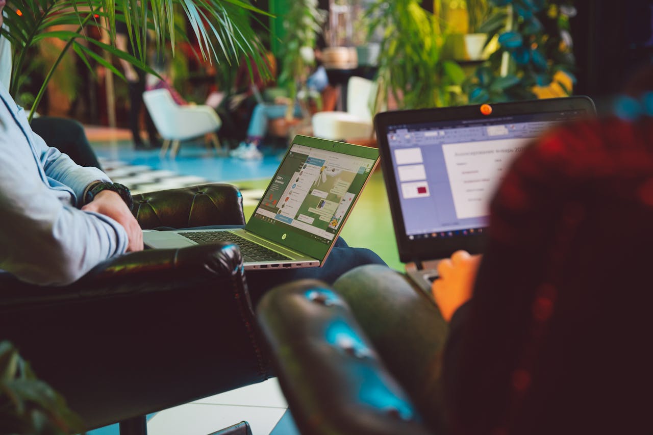 two-people-sitting-working-on-their-laptops