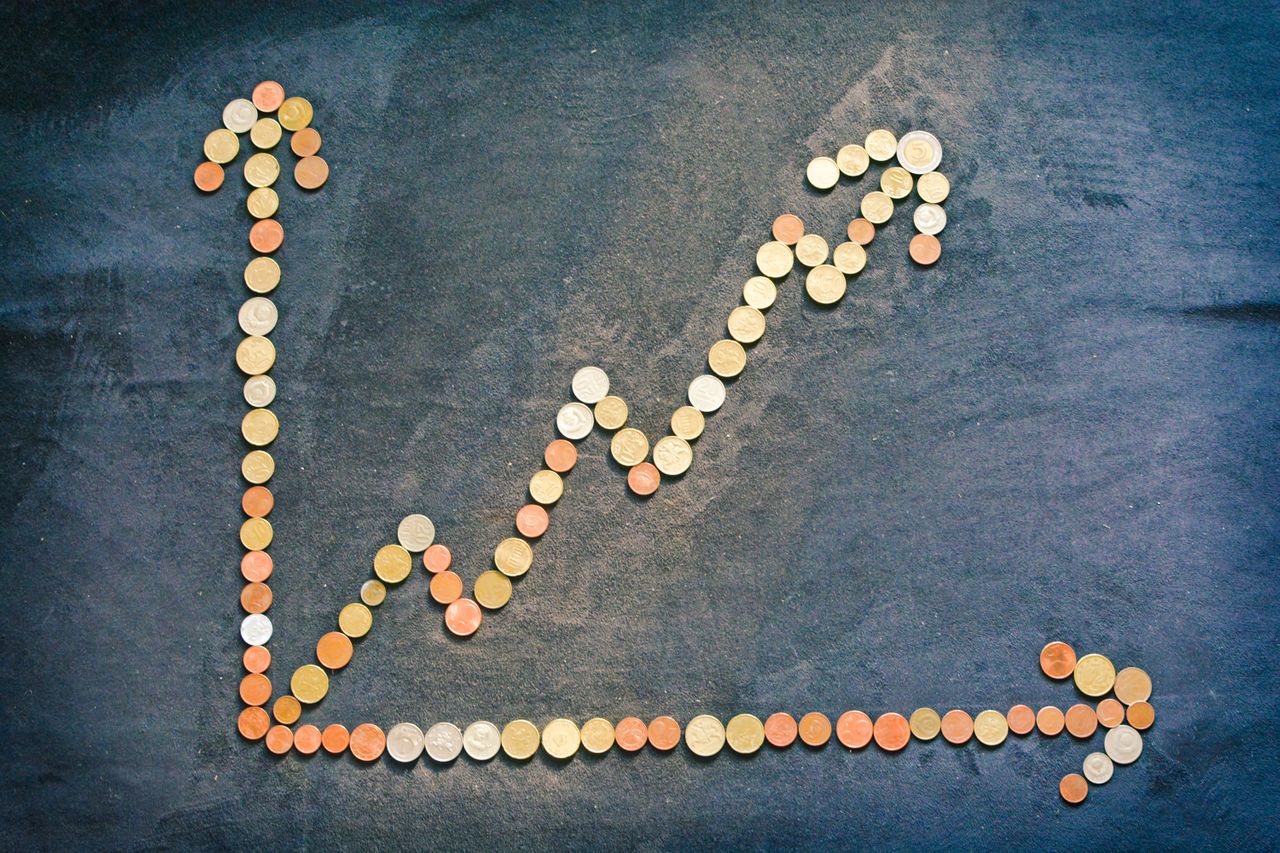 An upward trend graph made from coins representing financial growth