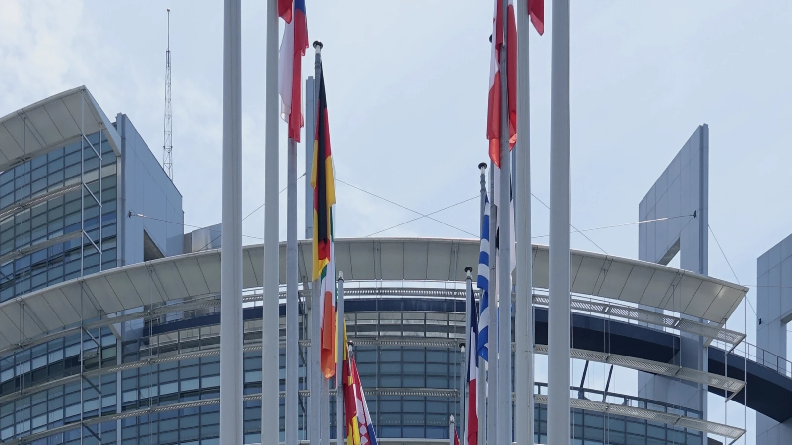 Exterior of the European Parliament building in Strasbourg, shown under a restrained navy editorial grade.