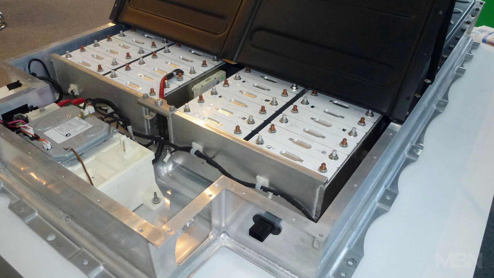 A BMW i3 battery pack displayed at the Electronica trade show in Munich in November 2012. Historical representative image, not a recycling operation. Photo: RudolfSimon, CC BY-SA 3.0; cropped and color-adjusted with an MBN watermark. Adapted cover: CC BY-SA 3.0.