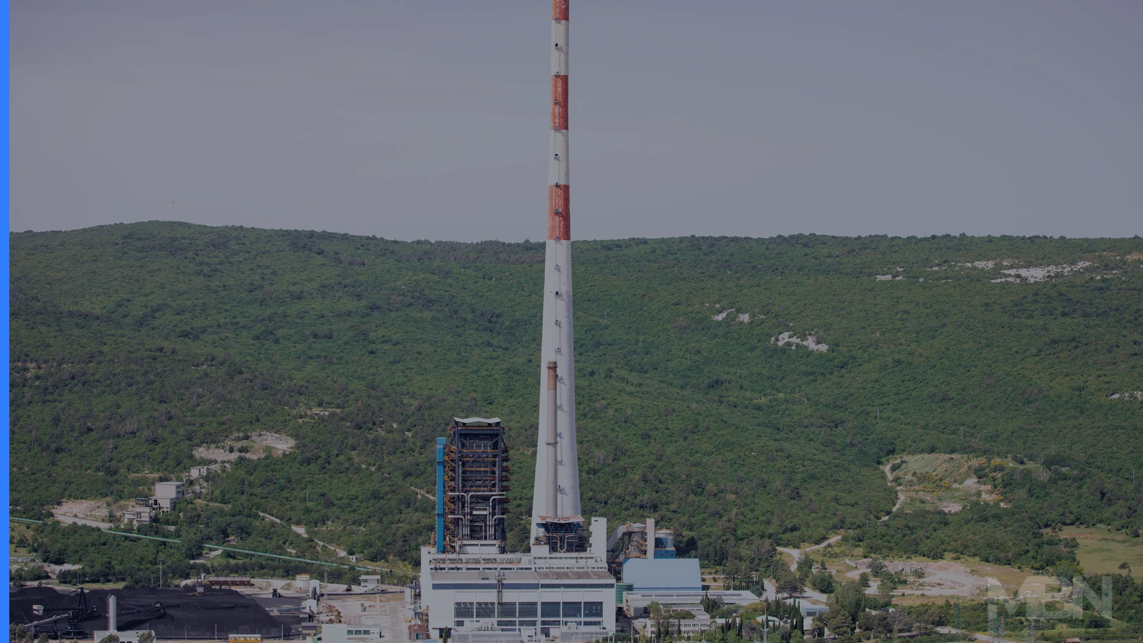 Editorial cover showing a coal-fired power plant beyond trees, representative of the global coal market. Image by Mussi Katz, CC0 via Wikimedia Commons.