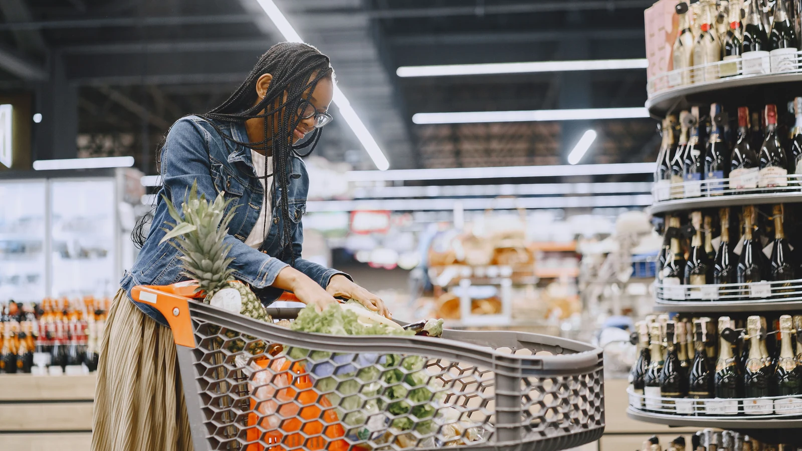 A shopper places groceries in a supermarket trolley in a representative stock photograph by Gustavo Fring/Pexels.