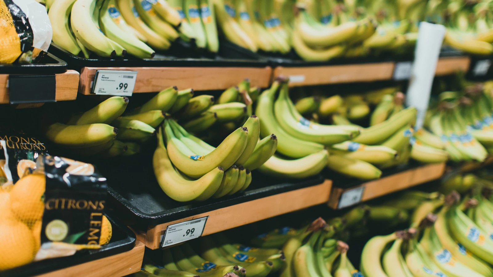 Bananas on grocery shelves with price labels, a representative retail photograph by Jonathan Cooper from Pexels under the Pexels License.