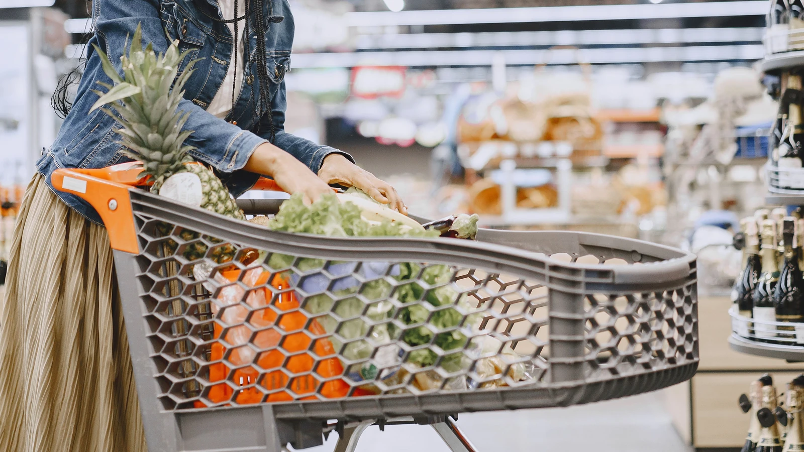 A grocery-filled trolley and a shopper’s hands in a supermarket, shown in a representative photograph by Gustavo Fring for Pexels.