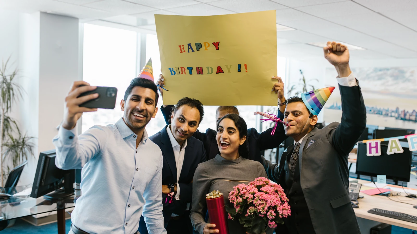 Colleagues wearing party hats pose for a photograph during an office birthday celebration, a representative stock image by RDNE Stock project/Pexels.