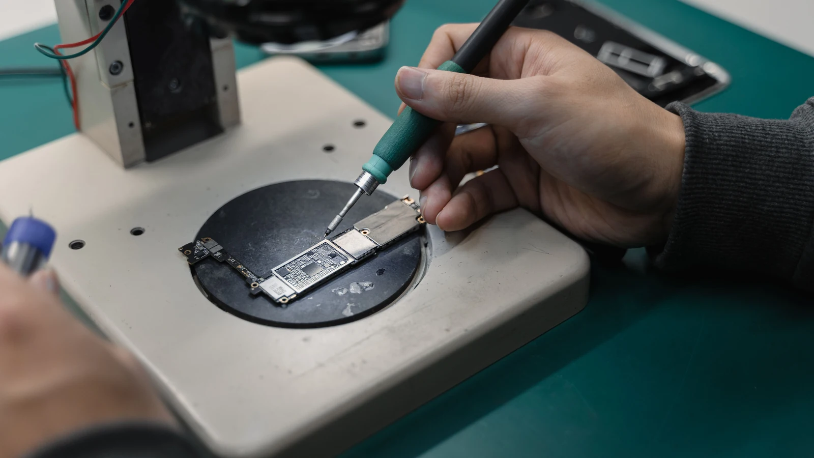 Hands work on an electronic circuit board with a soldering tool, a representative workshop stock photograph by Tima Miroshnichenko via Pexels.