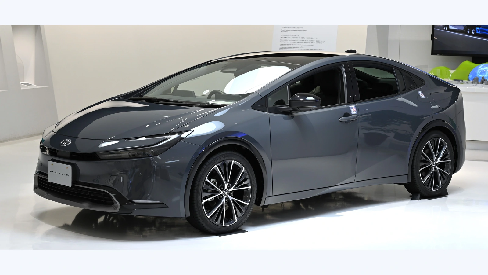 A Toyota Prius hybrid displayed indoors, representing the hybrid vehicle market; photograph by TTTNIS, CC0, unrelated to Honda’s planned models.