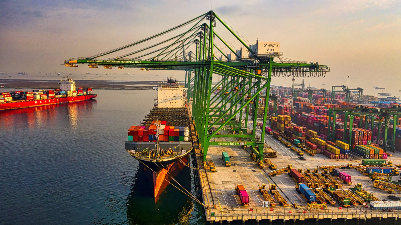 Container ships and cranes at a port in North Jakarta, Indonesia, representing international trade; photograph by Tom Fisk/Pexels.