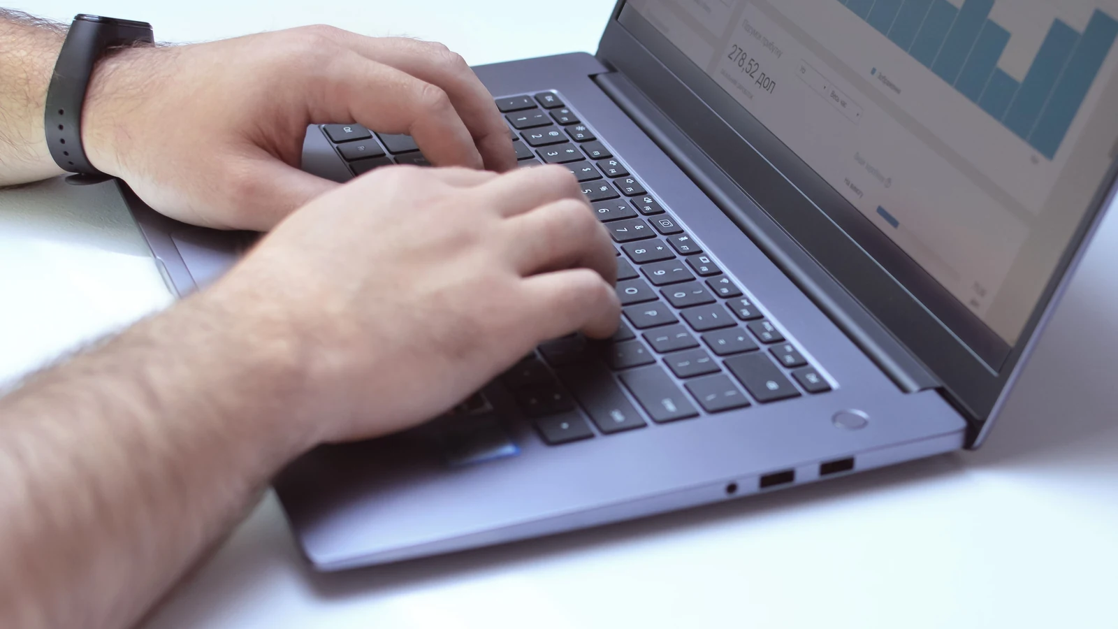 Hands typing on a laptop displaying charts at a desk, a representative stock photograph by Василь Вовк/Pexels.