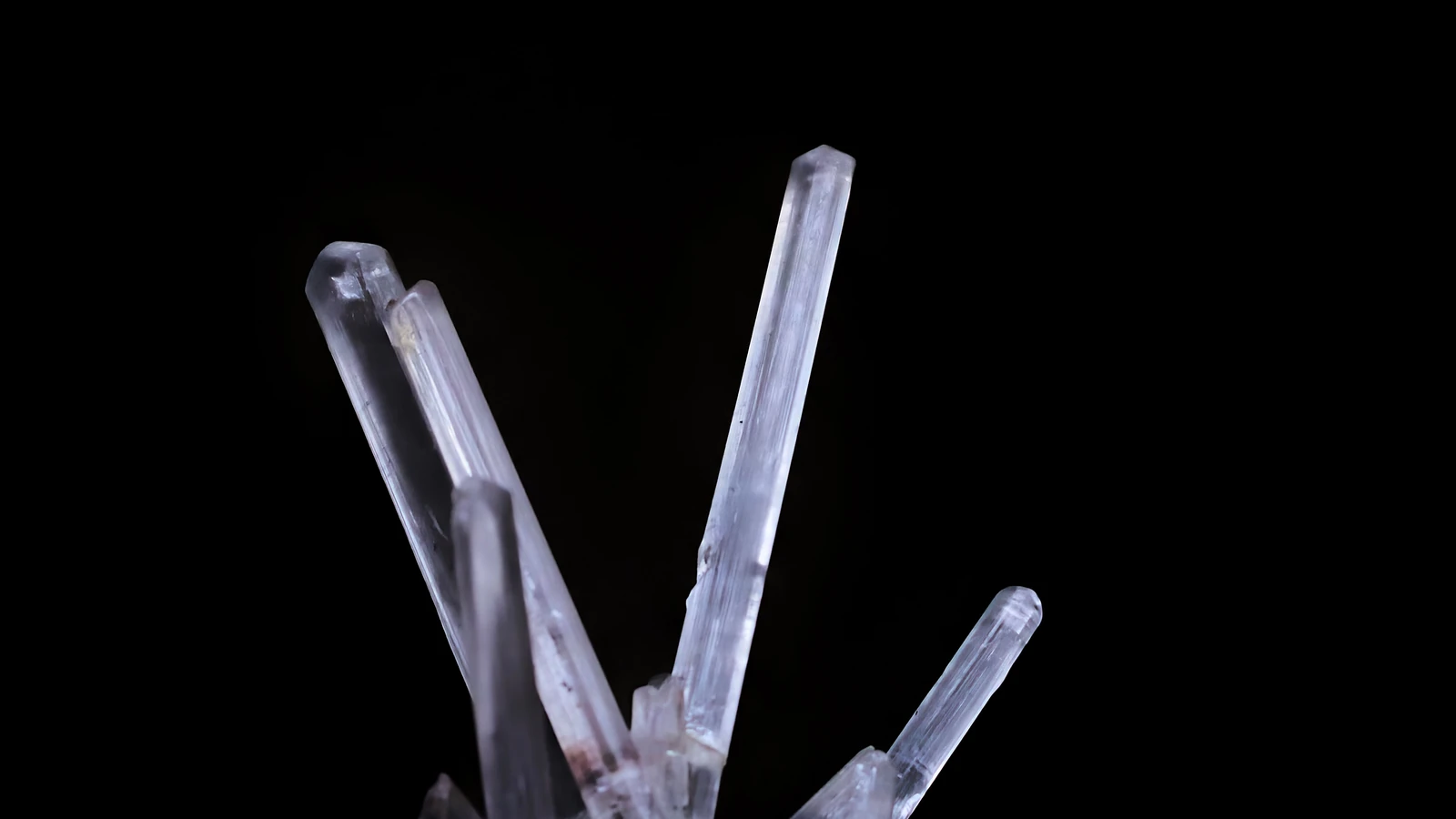 Clear quartz crystals against a dark background in a representative materials photograph by James Lee, used under the Pexels License.
