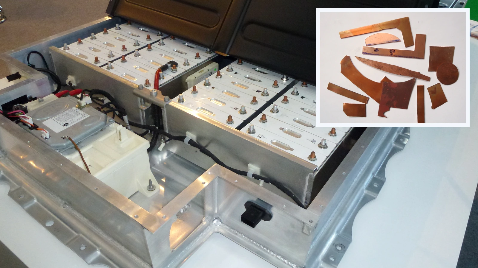Editorial composite showing an open electric vehicle battery pack with silver modules and connecting cables, with a separate framed photograph of copper scraps.