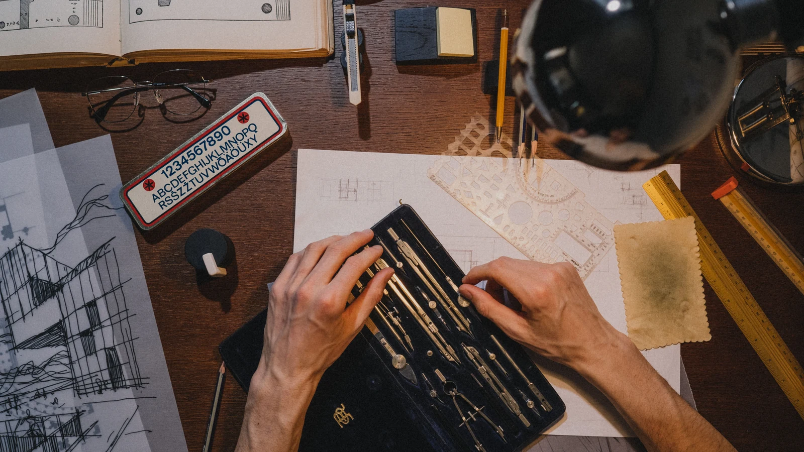 Architectural plans and drafting tools on a desk, photographed by Ron Lach for Pexels.