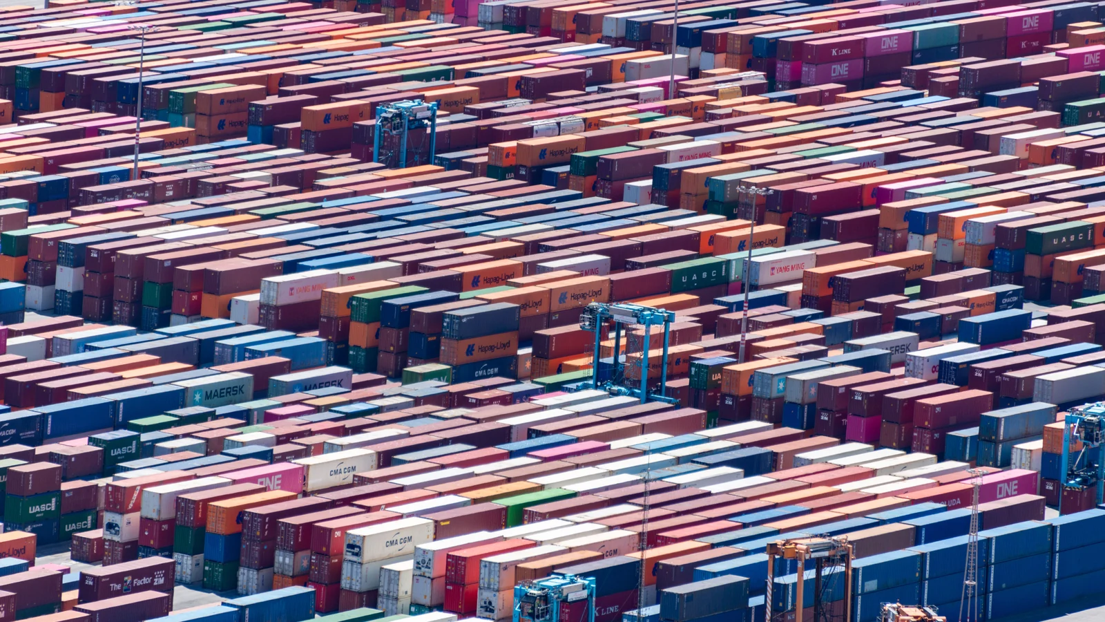 Shipping containers and handling equipment at a port, shown in a representative photograph by Diego F. Parra for Pexels.