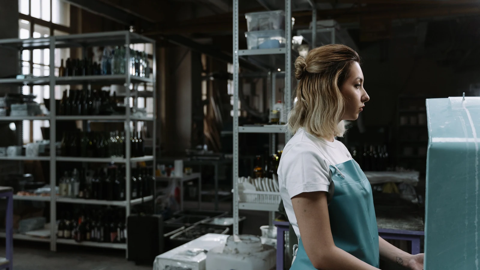 A worker stands beside machinery in a workshop, photographed by cottonbro studio for Pexels.